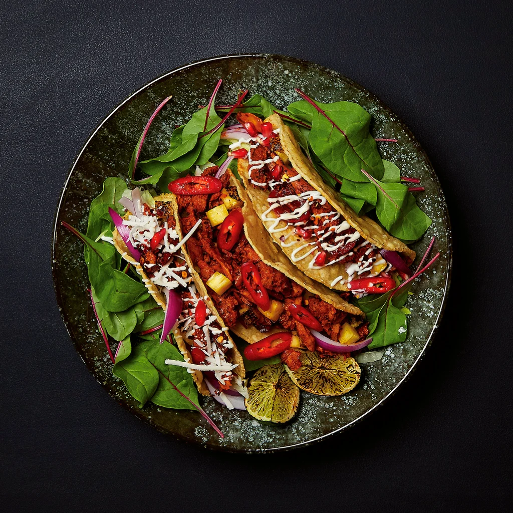Frisch angerichteter Kansas City Taco mit würziger Füllung, knackigem Gemüse, frischen Toppings und aromatischer Sauce auf einem Teller serviert.